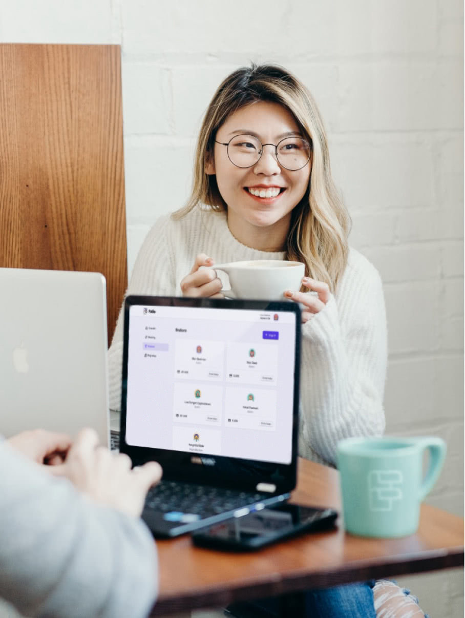 Smilende kvinne med kaffekopp og laptop med Folio sin nettbank